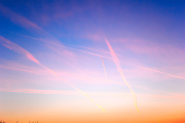 Spectacular sunset sky with vapour trails and high clouds.