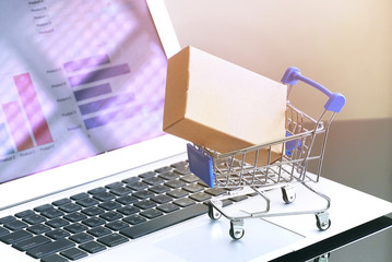 Packaging box on shopping cart with background computer screen,online shopping concept.