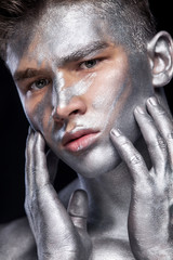 Wall Mural - A fashion portrait of man with silver bodyart and face art.