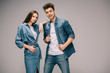 girlfriend in denim dress and smiling boyfriend in jeans and shirt looking at camera