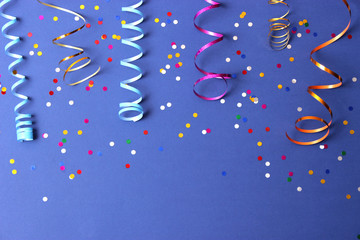  Festive background of ribbons and confetti on a colored background top view.