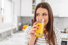 Close Up Of Teenage Girl Drinking Juice While Looking Through A Window