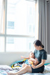 © themorningglory - Office women playing with infant baby boy in cozy room
