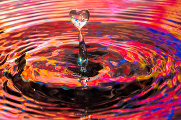 Water drop heart shape image in to colorful water