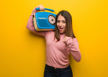 Young Cute Woman Holding A Vintage Radio Surprised, Feels Successful And Prosperous