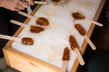 Wall Mural - Making maple candy on snow in a maple sugar camp in New Brunswick