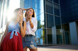 © artiemedvedev - Two young female friends having fun and eating ice cream. Cheerful caucasian women eating icecream outdoors in the city. Pretty girls posing with ice-cream. Summer time concept.