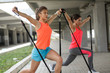 © BalanceFormCreative - Two young female work out on trx,suspension trainer.Outdoor workout.