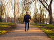 © anuskiserrano - A senior woman with white hair listening to music with headphones walking in an urban park