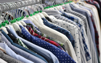 Elegant shirts on hangers in the store blurred. On the eve of Black Friday. Background for design from a department store.