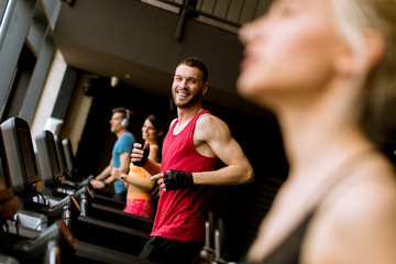 Wall Mural - young people running on treadmills in modern gym