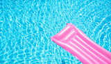 Fototapeta Przestrzenne - Beach summer holiday background. Inflatable air mattress on swimming pool water. Pink lilo and summertime accessories on poolside. Top view and copy space. Banner