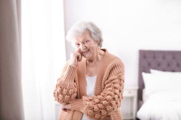 Wall Mural - Portrait of beautiful grandmother in sweater at home