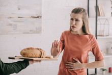Cropped View Of Man Holding Cutting Board With Bread Near Upset Blonde Woman With Gluten Allergy