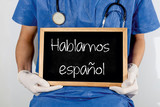 Fototapeta  - Doctor shows information on blackboard: we speak spanish.  Medical concept.