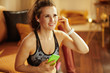 © Alliance - woman using online personal fitness trainer service in smartphon