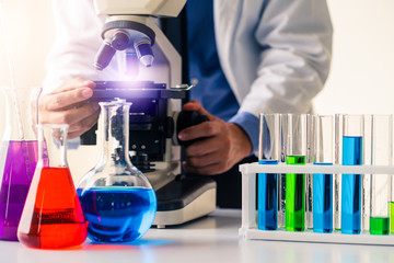 man scientist working in pharmaceutical laboratory and examining biochemistry sample in microscope. 