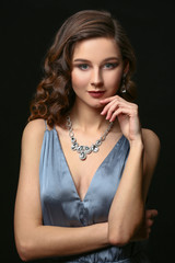 Wall Mural - Young woman with beautiful jewelry on dark background