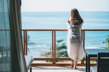 A Beautiful Asian Woman Standing And Enjoy Watching The Sea View At Balcony