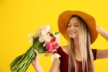 Poster - Young woman with bouquet of beautiful tulips on color background