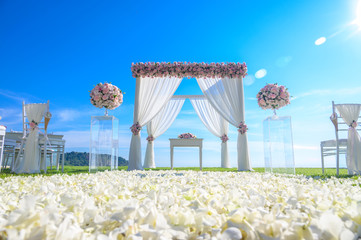 Wall Mural - Wedding ceremony. Arch, decorated with flowers on the lawn, beach background, sea in summer.