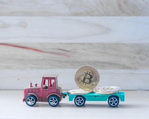 Cryptocurrency coin in white toy car on wooden table background, image gold coins on pattern wooden,