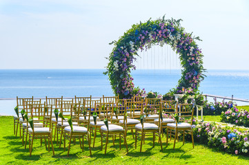 Wall Mural - Wedding ceremony. Arch, decorated with flowers on the lawn, beach background, sea in summer.