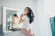 Portrait of her she nice-looking sweet winsome attractive lovely well-groomed perfect cheerful wavy-haired lady preparing date disco party blowing hair in light white interior room indoors