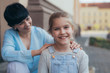 © cherryandbees - portrait of young girl with her mother in blurred background outdoor in the city