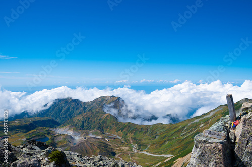 立山連峰 大汝山山頂の山頂標識と眼下に広がる室堂平および奥大日岳の景色 Stock Photo Adobe Stock 立山連峰 大汝山山頂の山頂標識と眼下に広がる室堂平および奥大日岳の景色 Stock Photo Adobe Stock