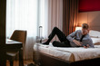 © JustLife - Businessman relaxing after meetings. Man checking his wifi connection at a hotel room.