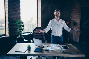 Close up photo handsome he him his macho guy cheer friendly look watch self-confident arms hands spread calling inviting visit candidate notebook table stand office wear specs formal wear white shirt