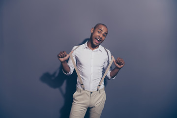Wall Mural - Close up photo beautiful amazing dark skin he him his macho hand arm hold suspenders childish playful mood excited shiny shaved face wear pastel white shirt pastel pants isolated grey background