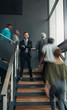 © JonoErasmus - Trendy indian, arabic businessman standing on a busy staircase smiling with his arms crossed