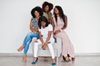 © AS Photo Family - Happy brightful positive moments of four african girls. Having fun and smiling on chair against white empty wall. Lovely moments of four best friends.