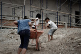 Fototapeta Niebo - Child labor in building commercial building structures. World Labor Day concept
