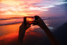Girl Takes A Sunset Photo On The Phone