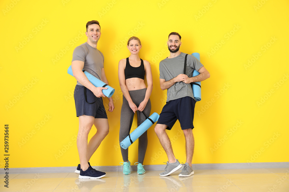 Sporty young people near color wall