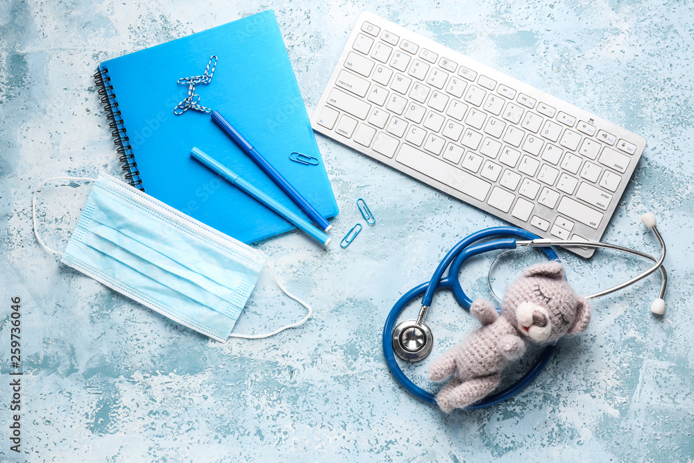 PC keyboard, stethoscope, mask, stationery and toy on color background