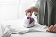 © Pixel-Shot - Woman ironing clothes at home