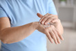 © Pixel-Shot - Mature woman applying hand cream at home, closeup