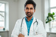 Indian doctor with stethoscope around neck in his office