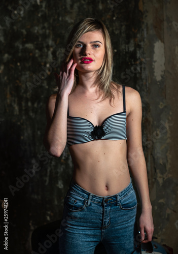 Fotomural Beautiful young girl in bodice and jeans in the old studio
