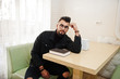 © AS Photo Family - Arab man wear on black jeans jacket and eyeglasses sitting in cafe, read book. Stylish and fashionable arabian model guy.