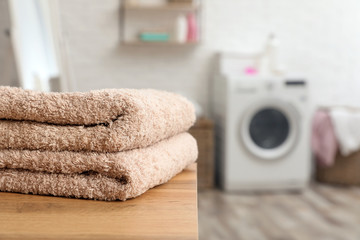 Wall Mural - Stack of towels on table against blurred background, space for text