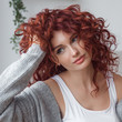 © olenachukhil - Very attractive young woman indoors. Portrait of curly haired female. Redhaired beautiful woman at home.