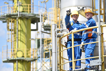 Wall Mural - Arbeiter in der Industrie in einer Raffinerie - Teamwork // teamwork: group of industrial workers in a refinery - oil processing equipment and machinery