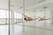 © Alvaro Hernandez/ADDICTIVE STOCK - Young slim strong woman practicing on pole in light room studio
