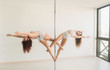 © Alvaro Hernandez/ADDICTIVE STOCK - Side view of young slim ladies training on pole with bodies to sides in light room near window
