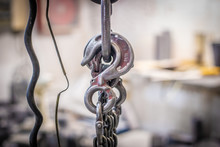 Closeup Hoisting Machine With Iron Chains On Little Foundry On Blurred Background